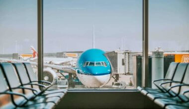 一架蓝色商用飞机停放在机场的门口